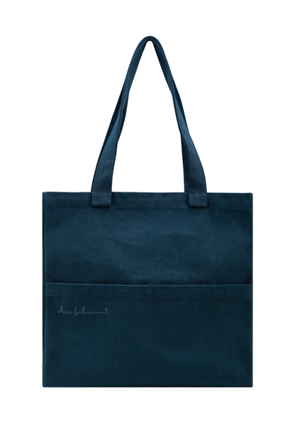 Front view of eco-friendly dark blue tote bag with Des Fabricant logo and dual outer pockets - sustainable everyday essential.