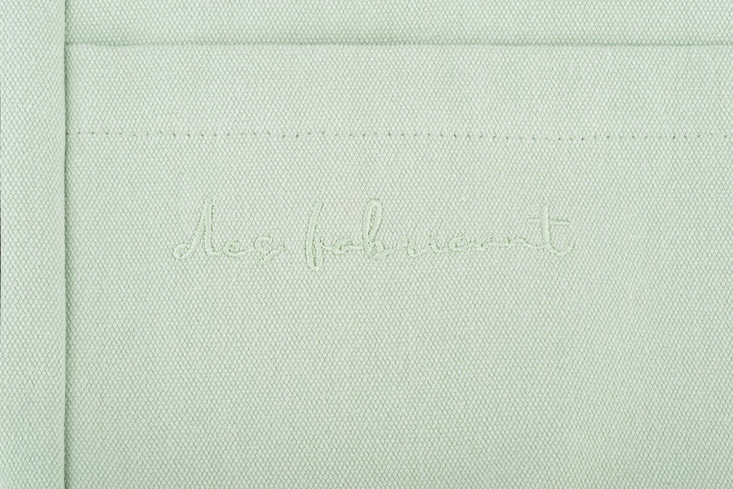Close-up of Des Fabricant logo embroidery on premium seafoam green cotton - subtle and
refined brand detailing.