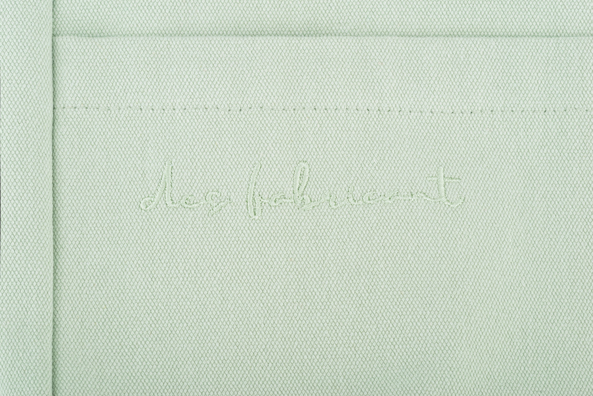 Close-up of Des Fabricant logo embroidery on premium seafoam green cotton - subtle and
refined brand detailing.